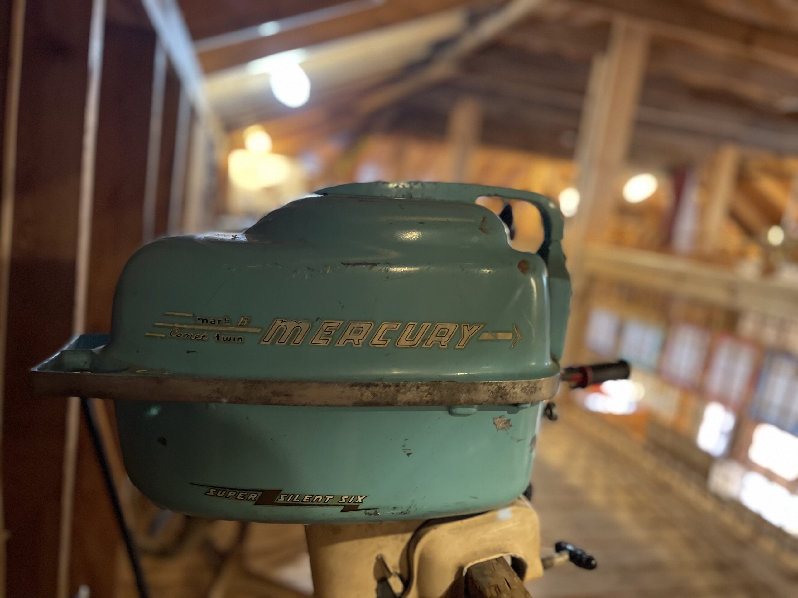 A vintage Mercury outboard motor in turquoise.