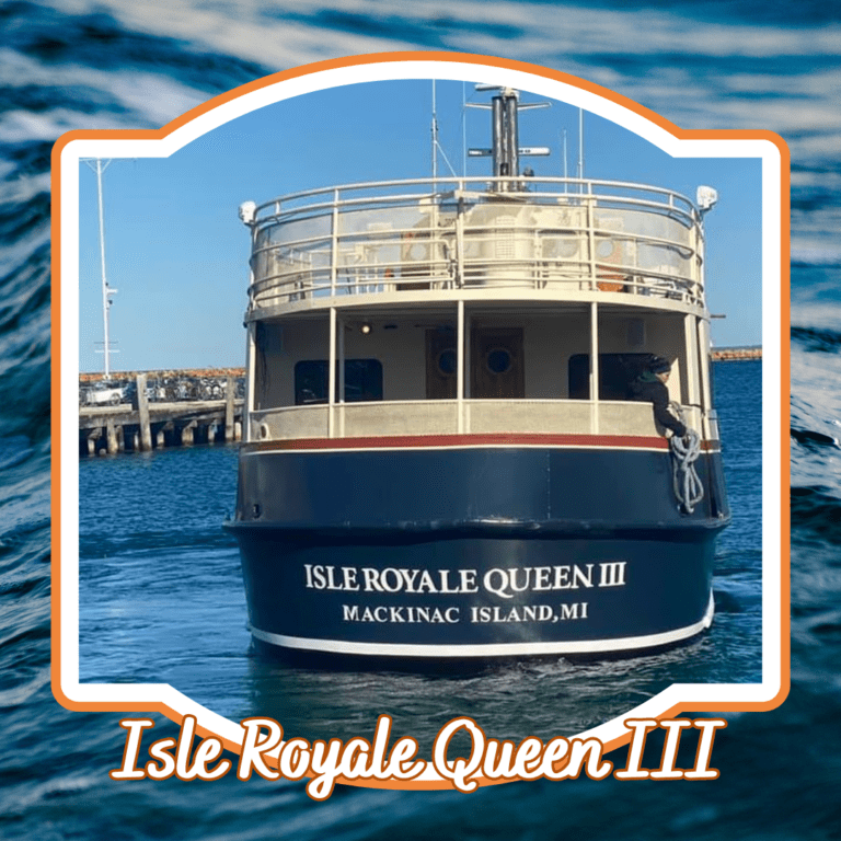 The Isle Royale Queen III docked at Mackinac Island, MI, with "Isle Royale Queen III" written in orange text over a water background.