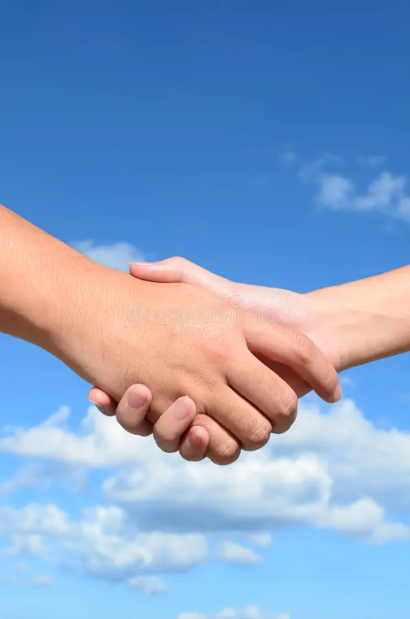 Two hands shaking against a clear blue sky with a few scattered clouds.